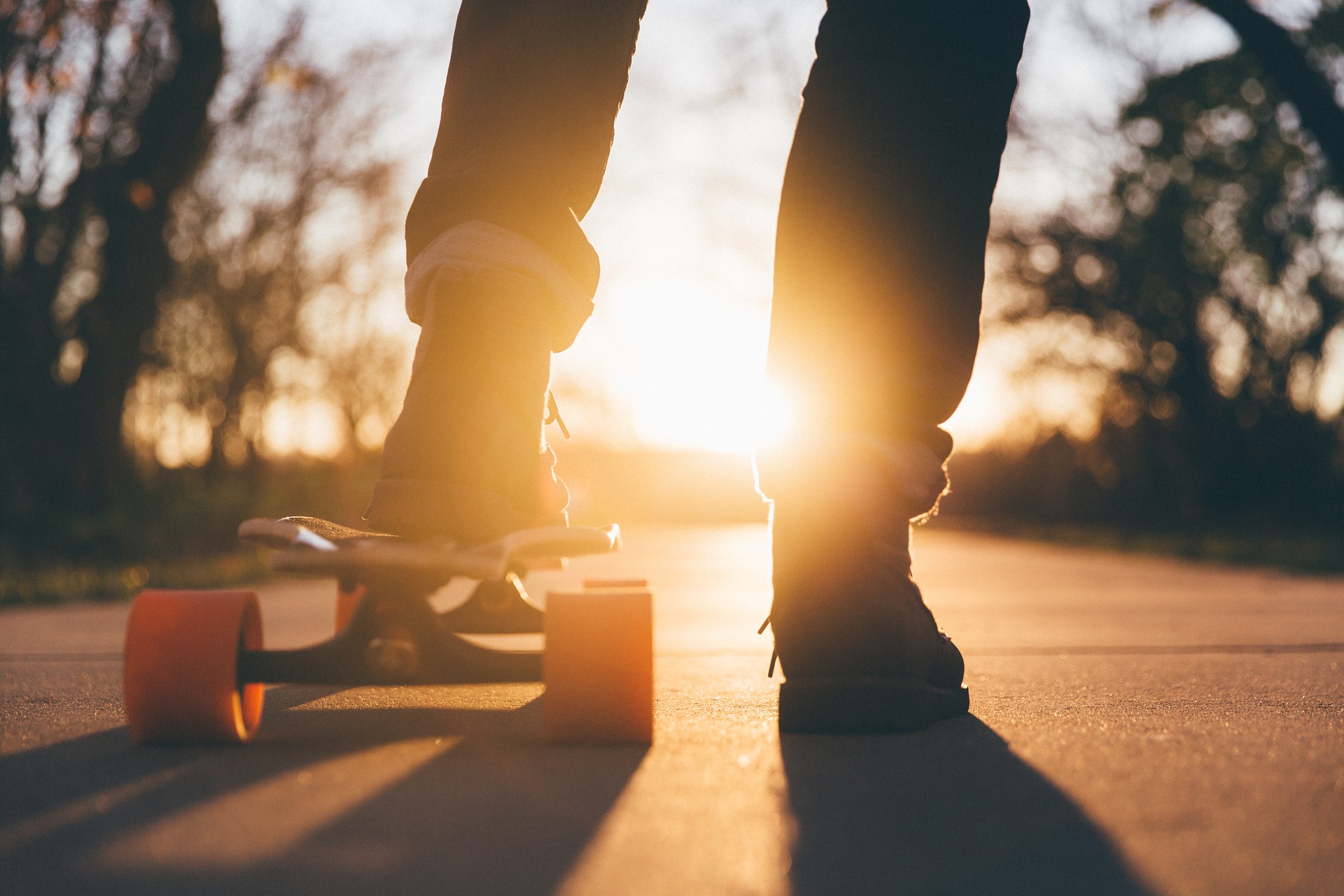 en person i jeans står med en a foten på en skateboard