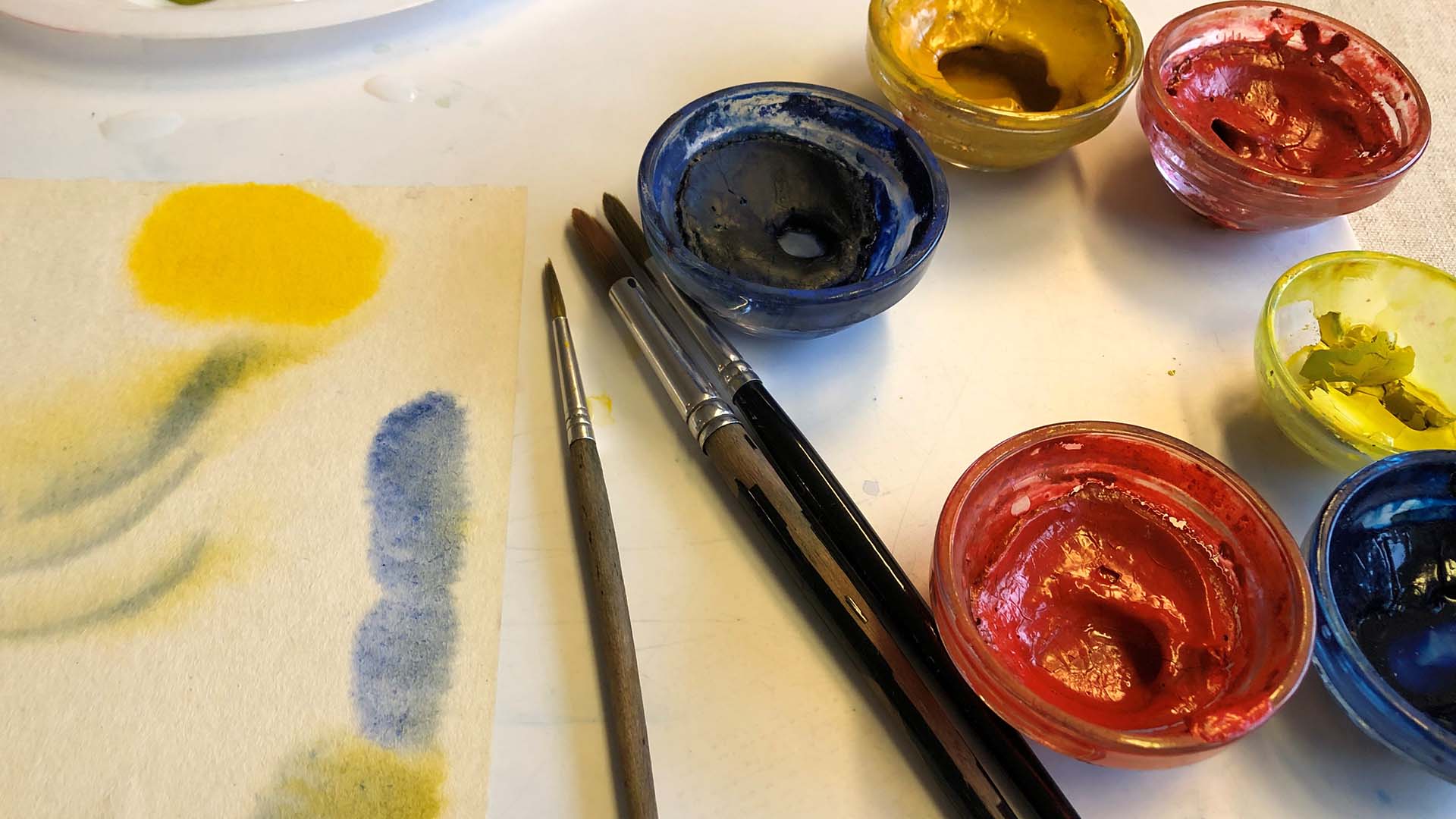 målargrejer - penslar och små skålar med färger