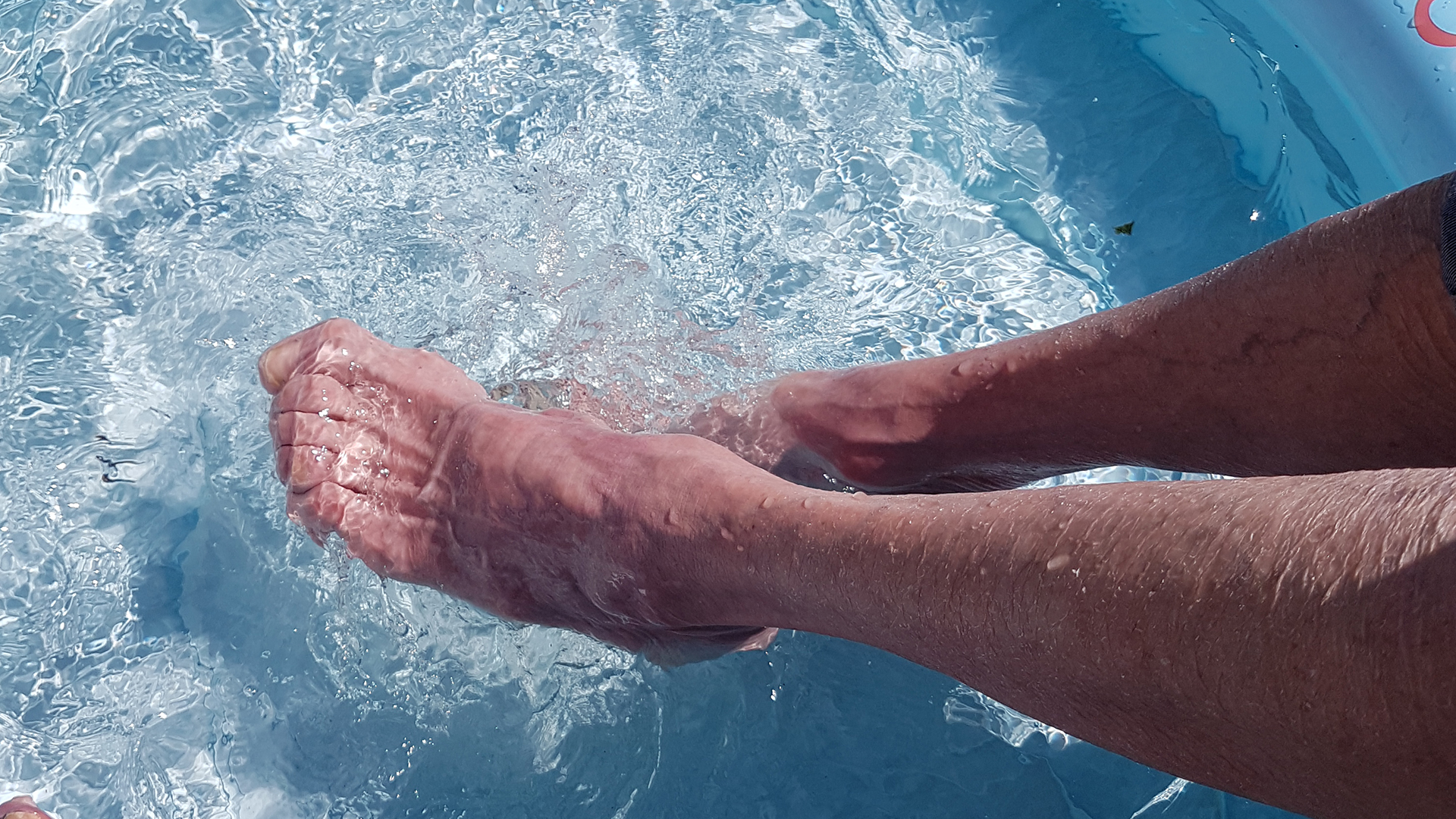 en person badar fötterna i en turkos pool