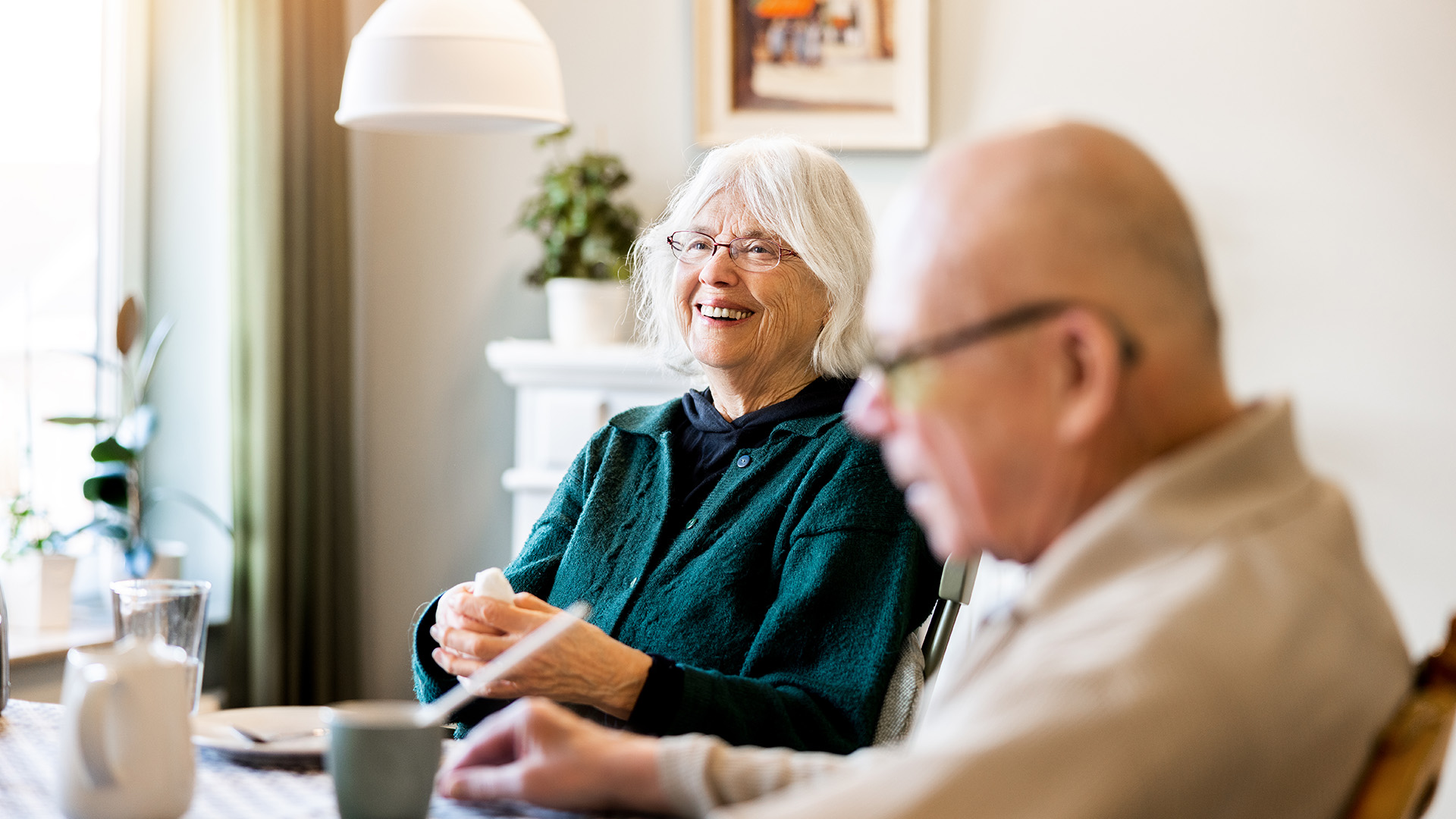 man och kvinna sitter vid ett bord och ler tillsammans