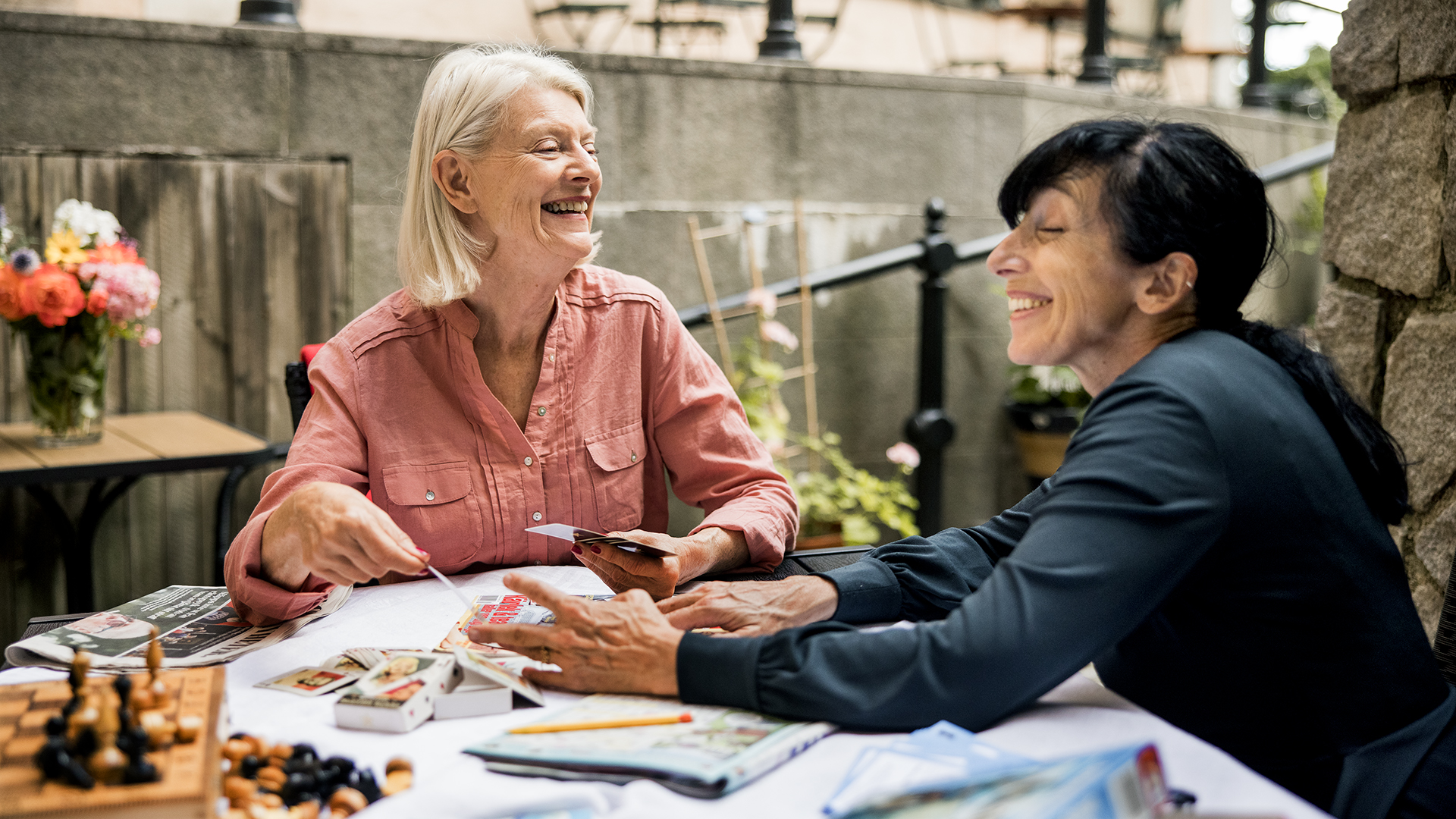 en yngre och en äldre kvinna sitter vid ett bord utanför dagverksamheten Villa Cederschiöld