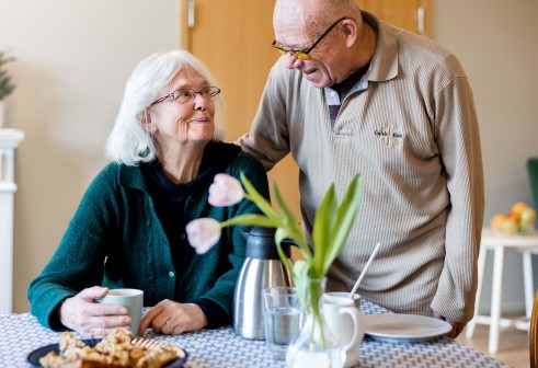 Två äldre personer som samtalar vid ett bord