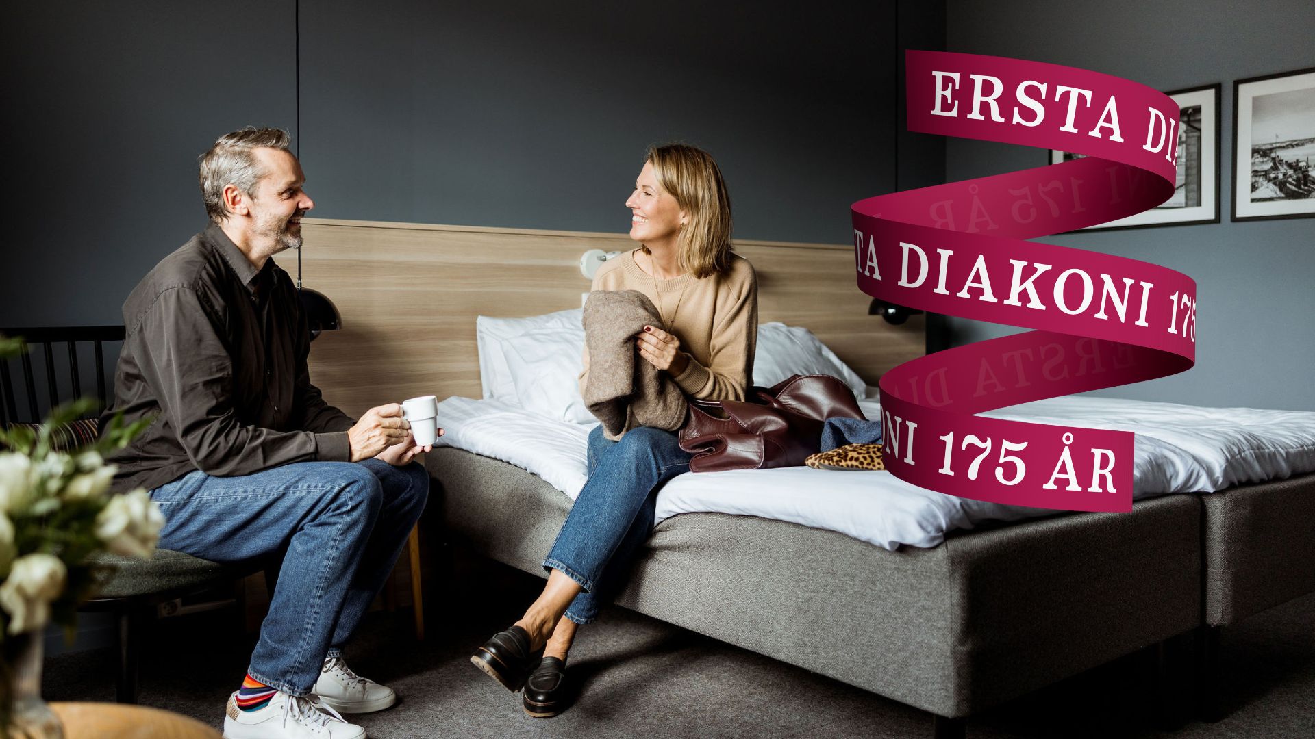 Ett par sitter på ett hotellrum och är glada. 