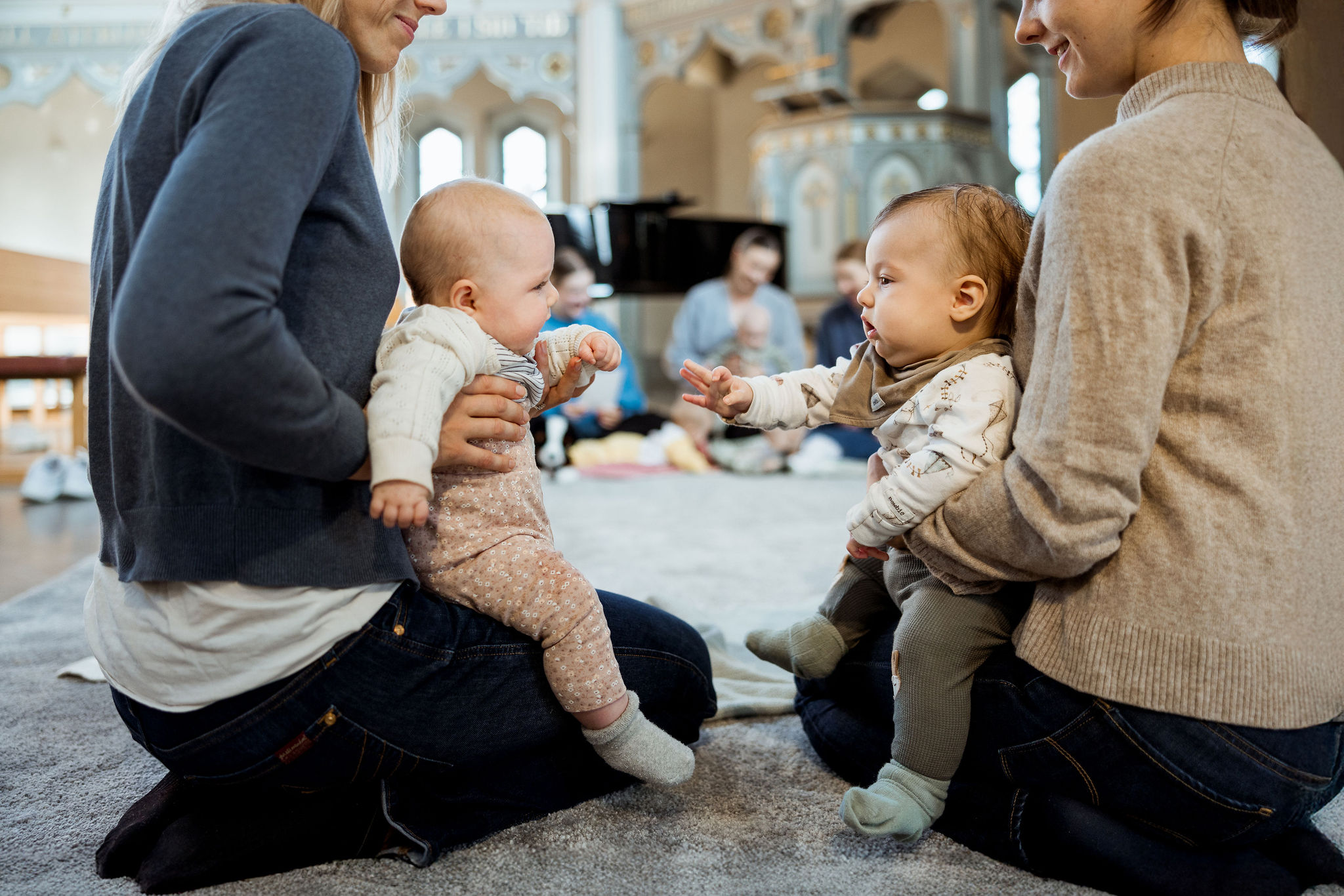 Föräldrar sjunger med sina bebisar i Ersta kyrka