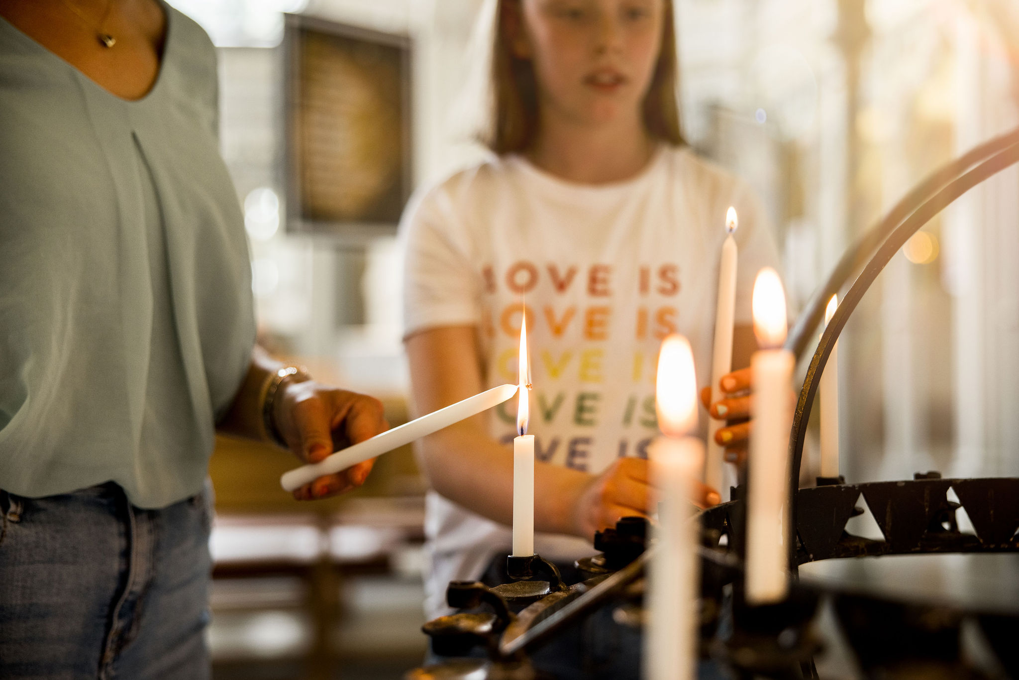 barn tänder ljus i kyrkan