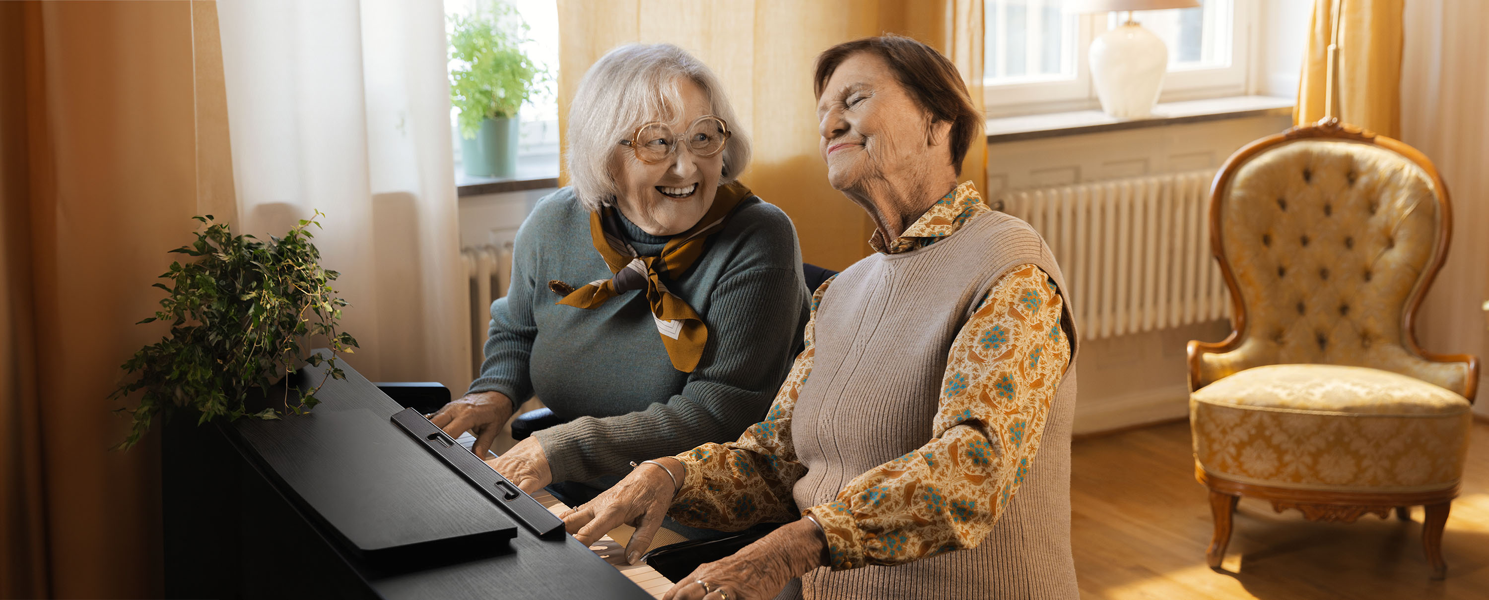 Två äldre damer spelar piano ihop