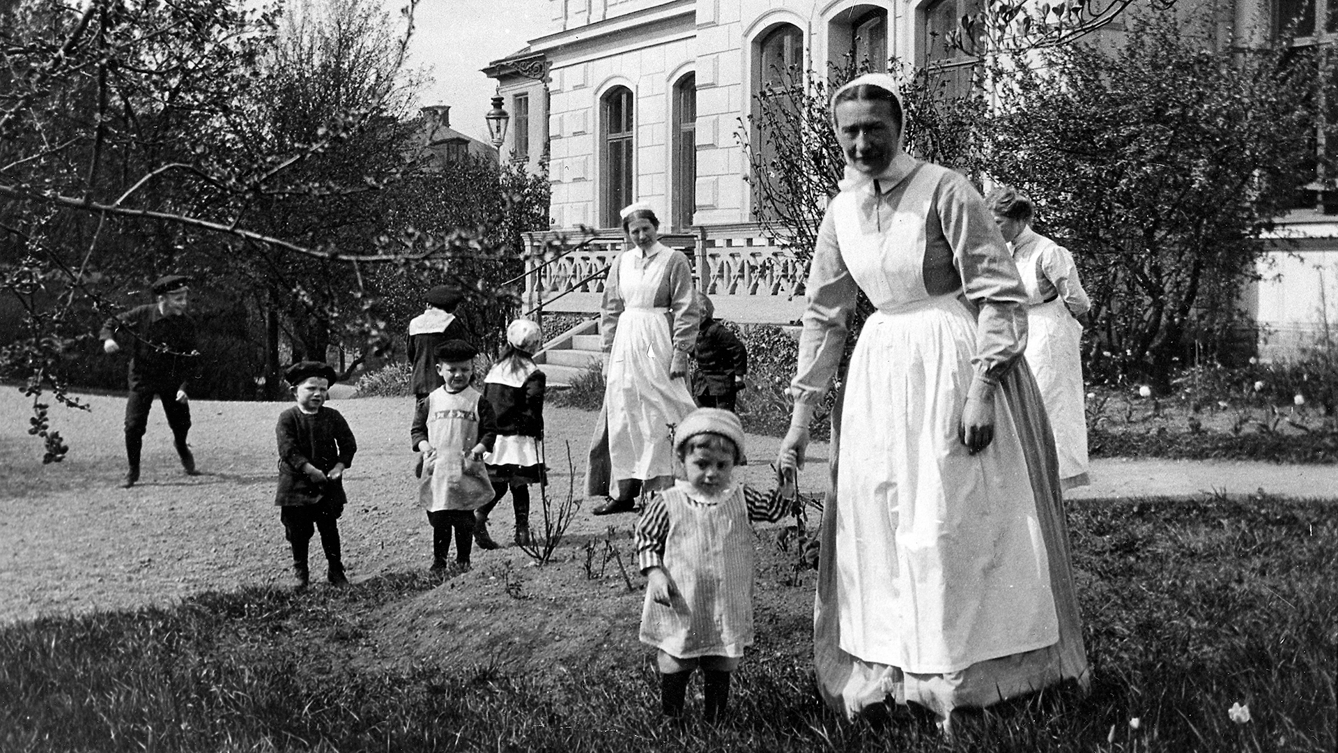 Sjuksyster och barn framför gamla Ersta sjukhus
