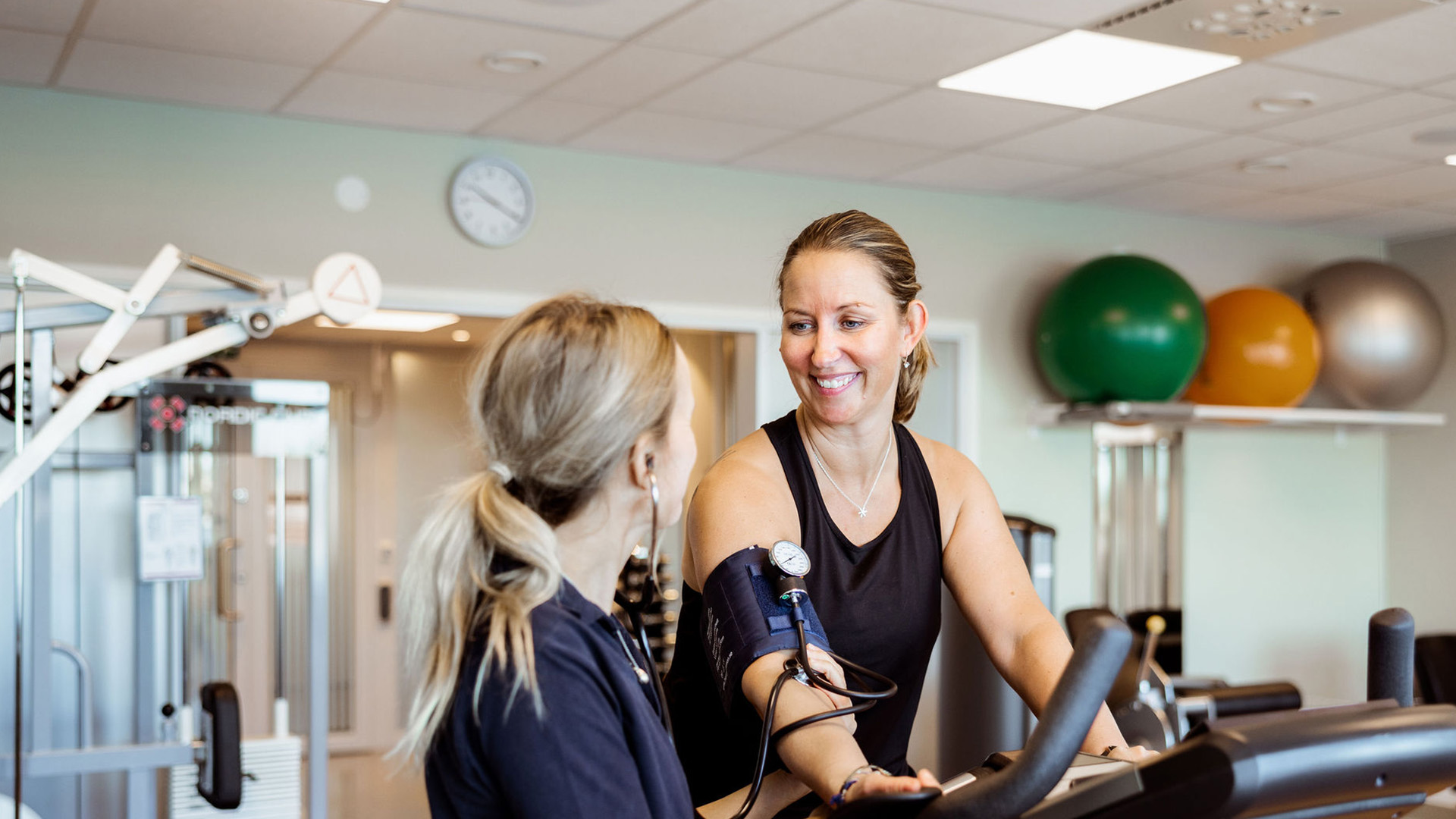 patient på träningscykel med personal bredvid