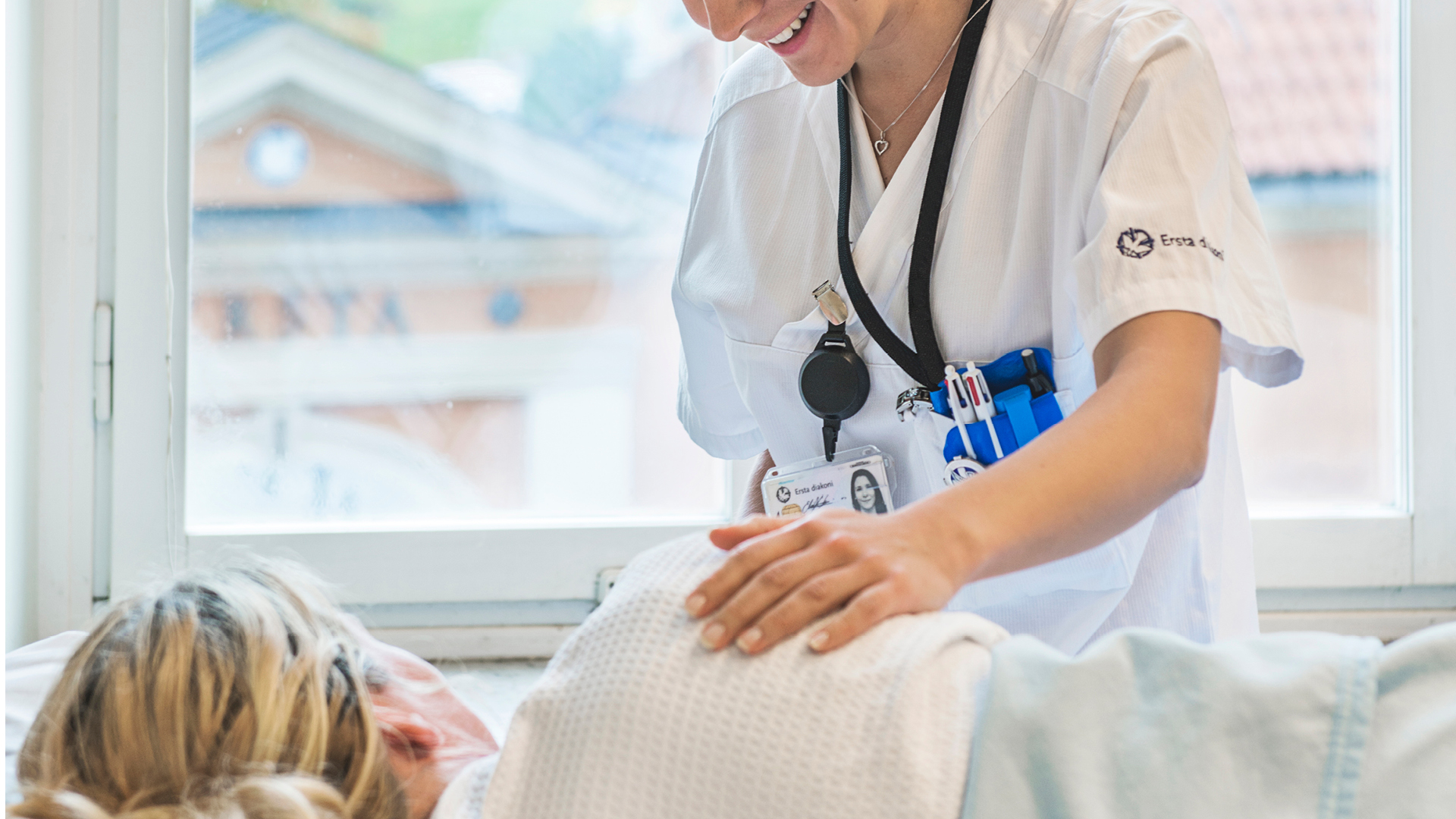 en anställd vid ersta sjukhus klappar en patient på axeln