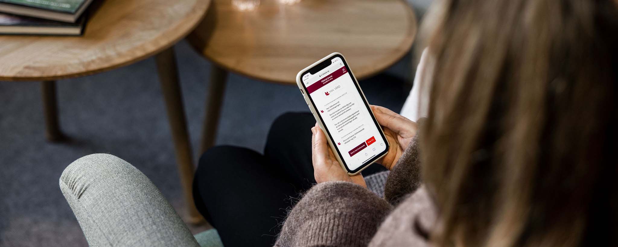 Kvinna sitter med en mobiltelefon