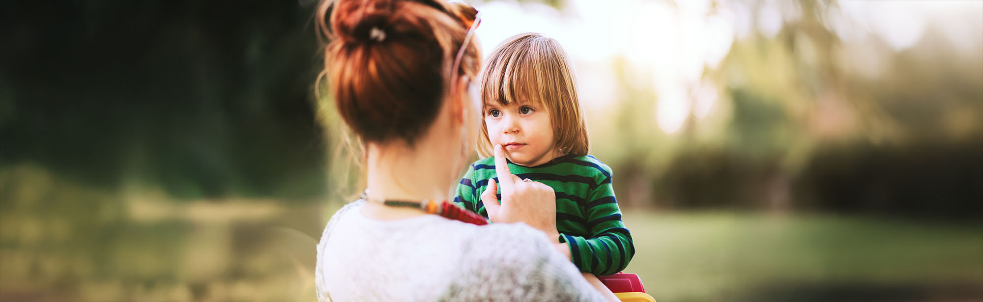 Mamma och barn håller handen i stadsmiljö