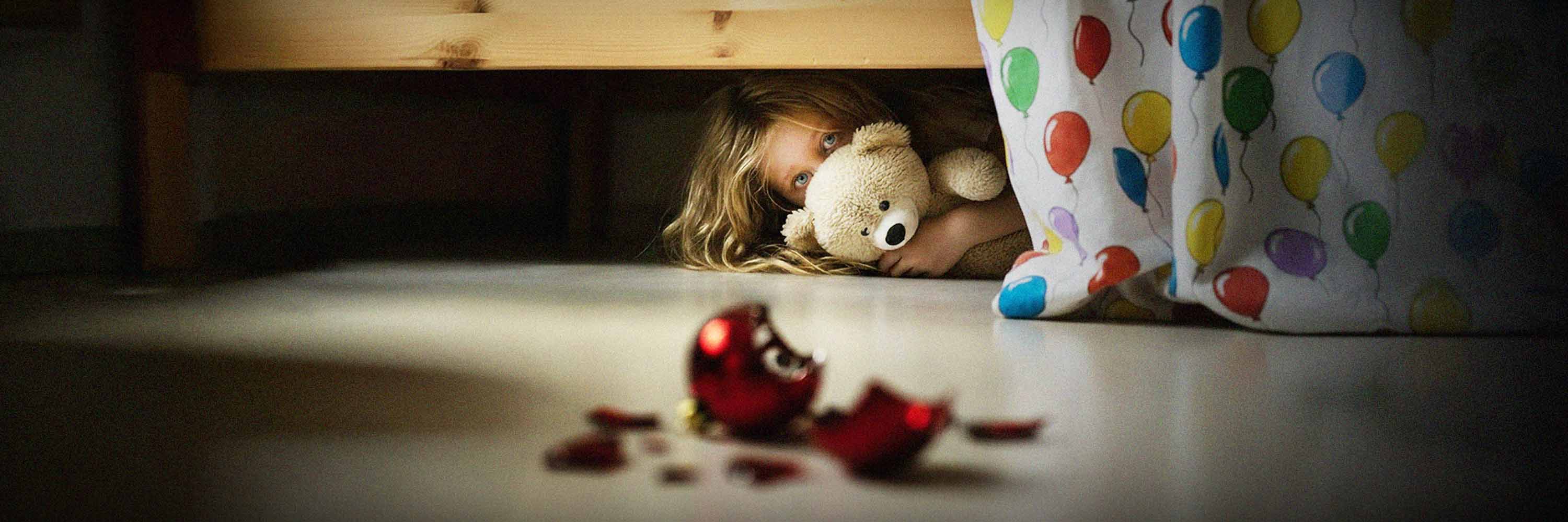 Ett barn och hens mamma håller om varandra i ett lekrum..